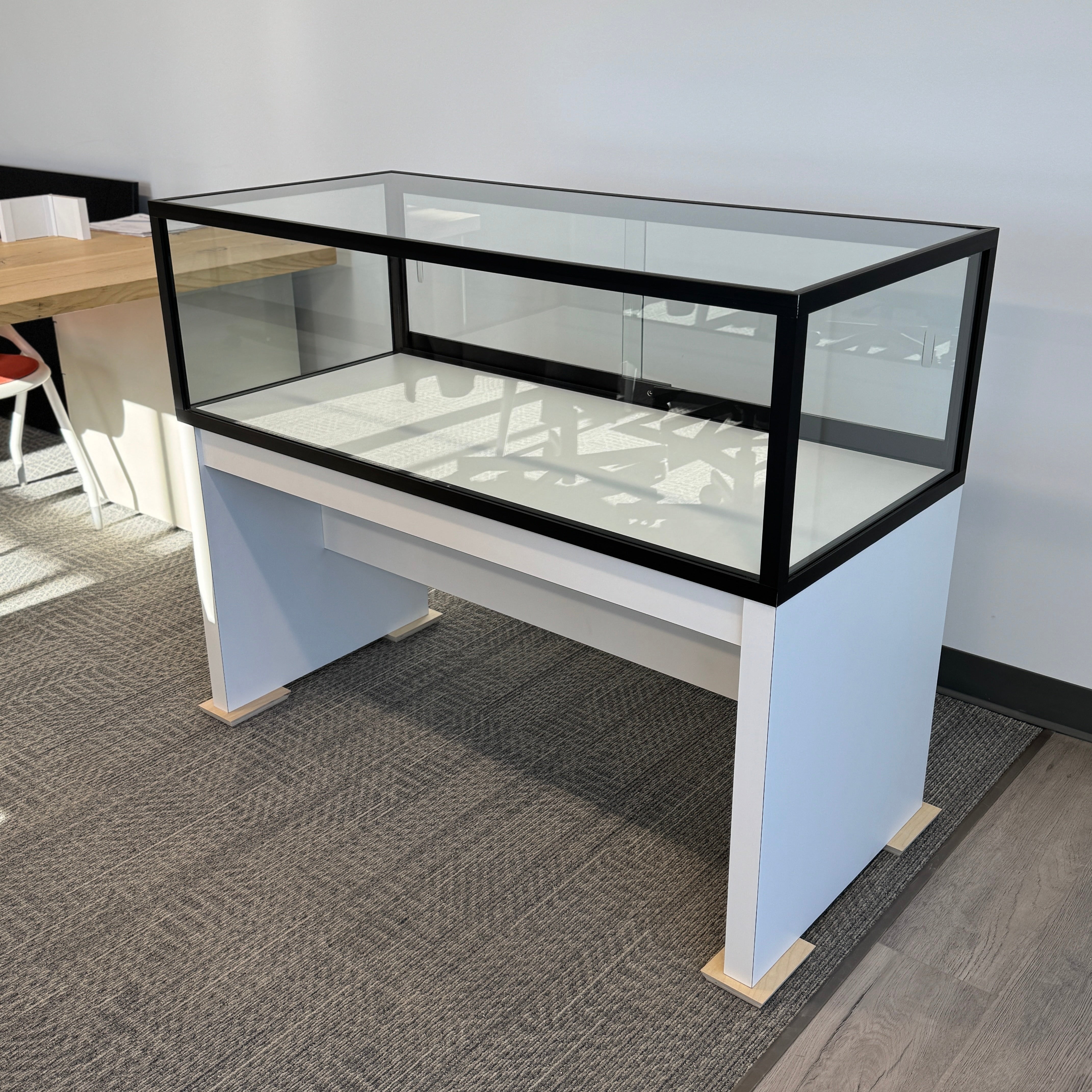 Glass display case on a white desk in an office setting